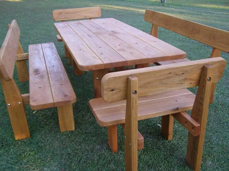 Five-piece hardwood picnic setting with four backed benches on grass