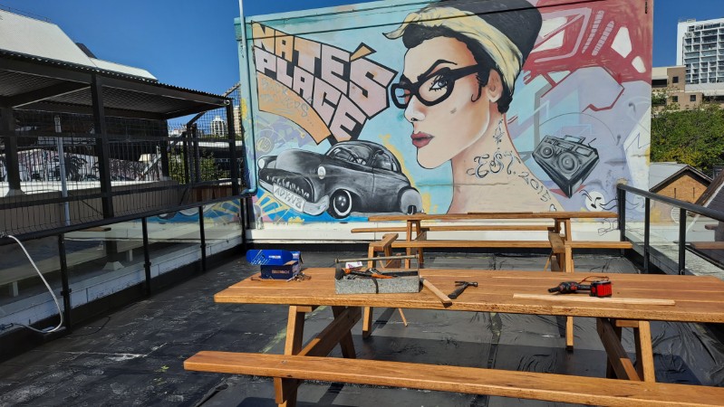 Assembling outdoor furniture on roof at backpackers