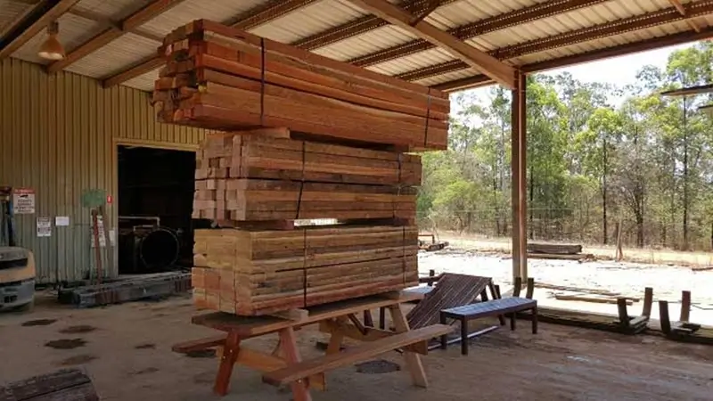Billabong picnic table supporting a large stack of Australian hardwood