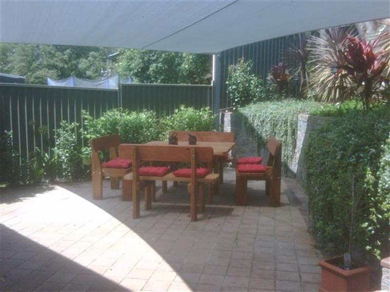 square hardwood outdoor setting with red cushions