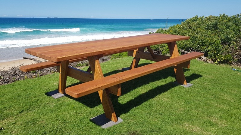 A long picnic table by the sea