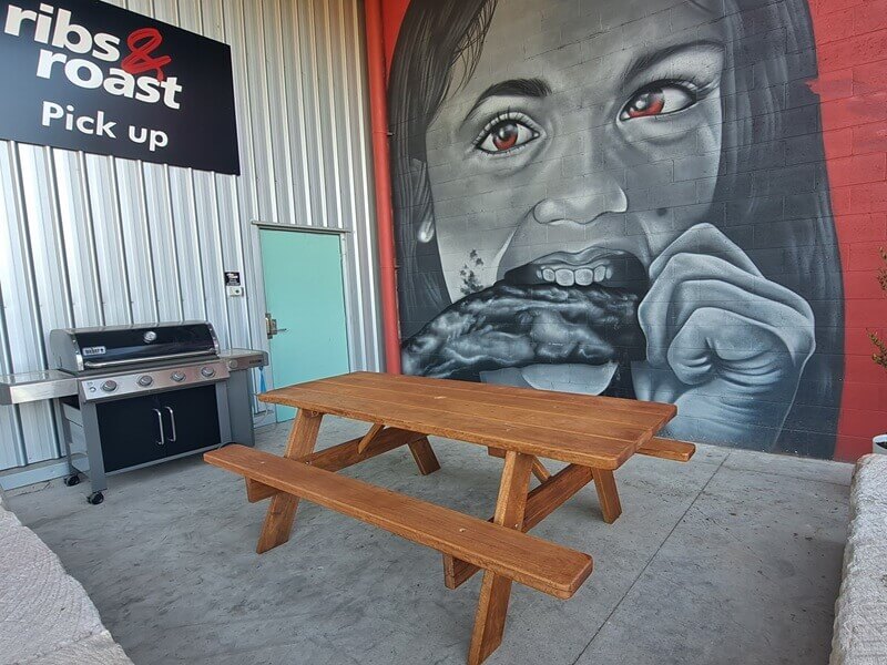 Picnic table and mural at Ribs & Roast The Outlet
