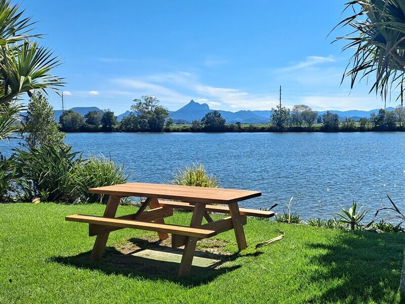 A solid picnic table on grass looking out at Mount Warning
