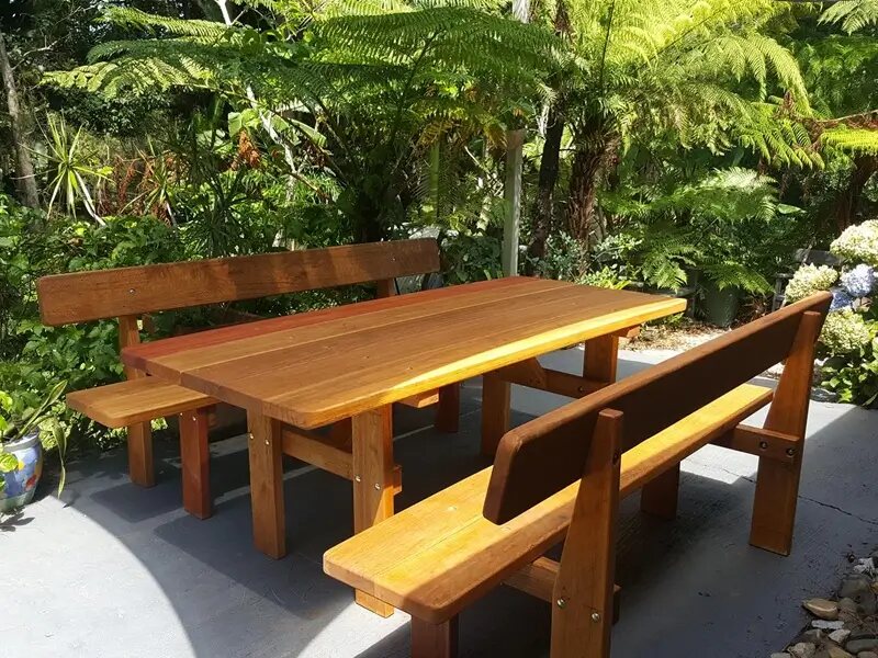Three-piece picnic table and benches with backrests in a tropical garden