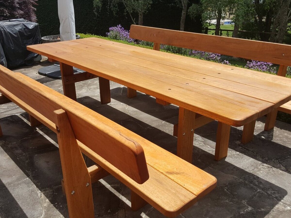 Long wooden garden table with separate backrest benches